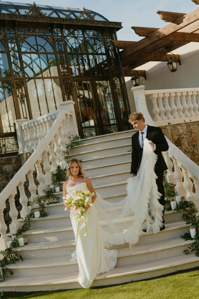 editorial pose bride and groom on marble staircase on wedding day 