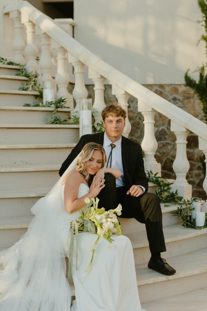 editorial pose bride and groom on marble staircase on wedding day 