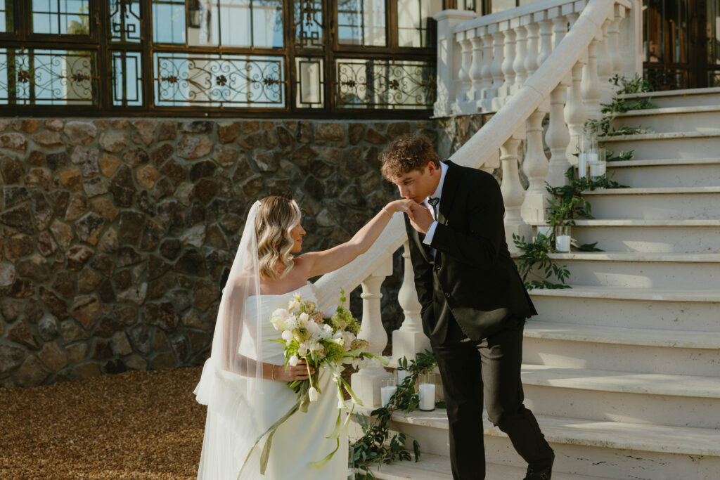 groom kissing brides hand on wedding day