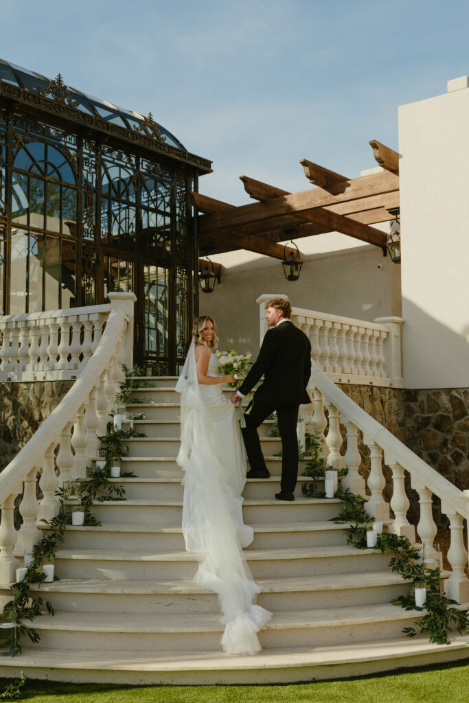 editorial pose bride and groom on marble staircase on wedding day 