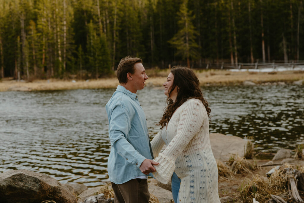 man and woman at engagement session in front of lake