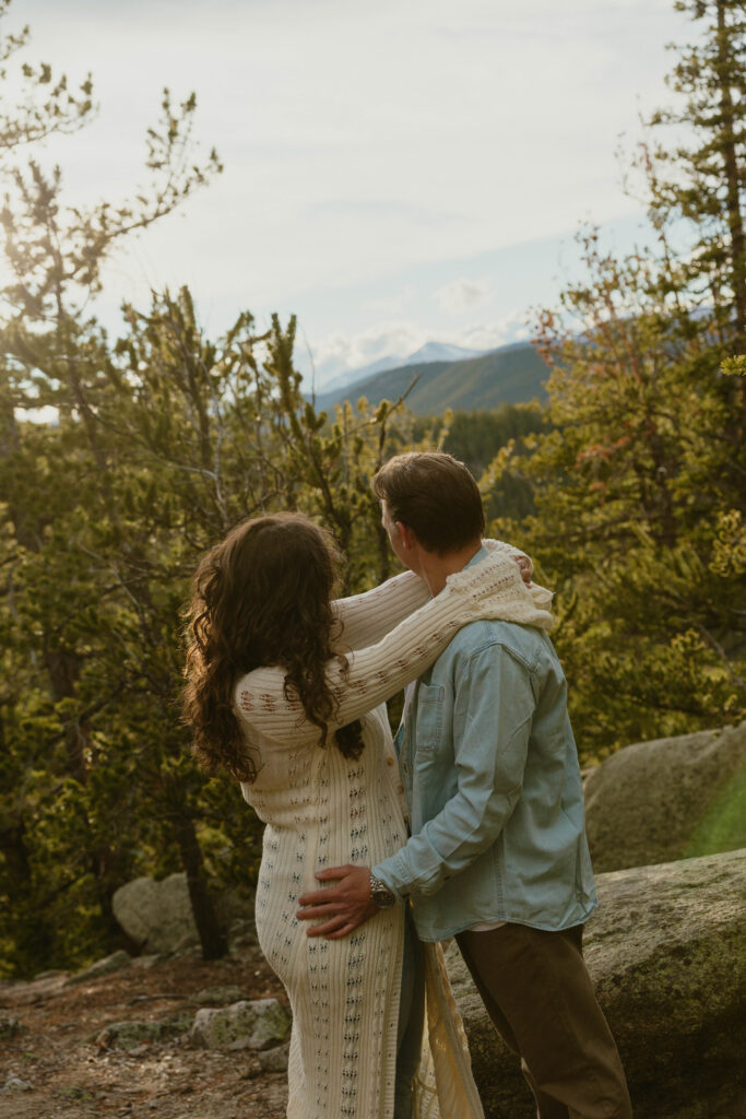 man and woman holding each other and looking away from camera. posing for engagement session