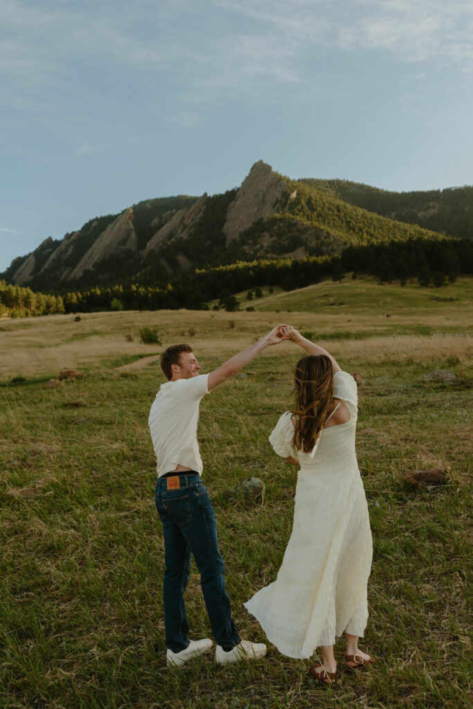 Couple twirling in the mountains during engagement photos