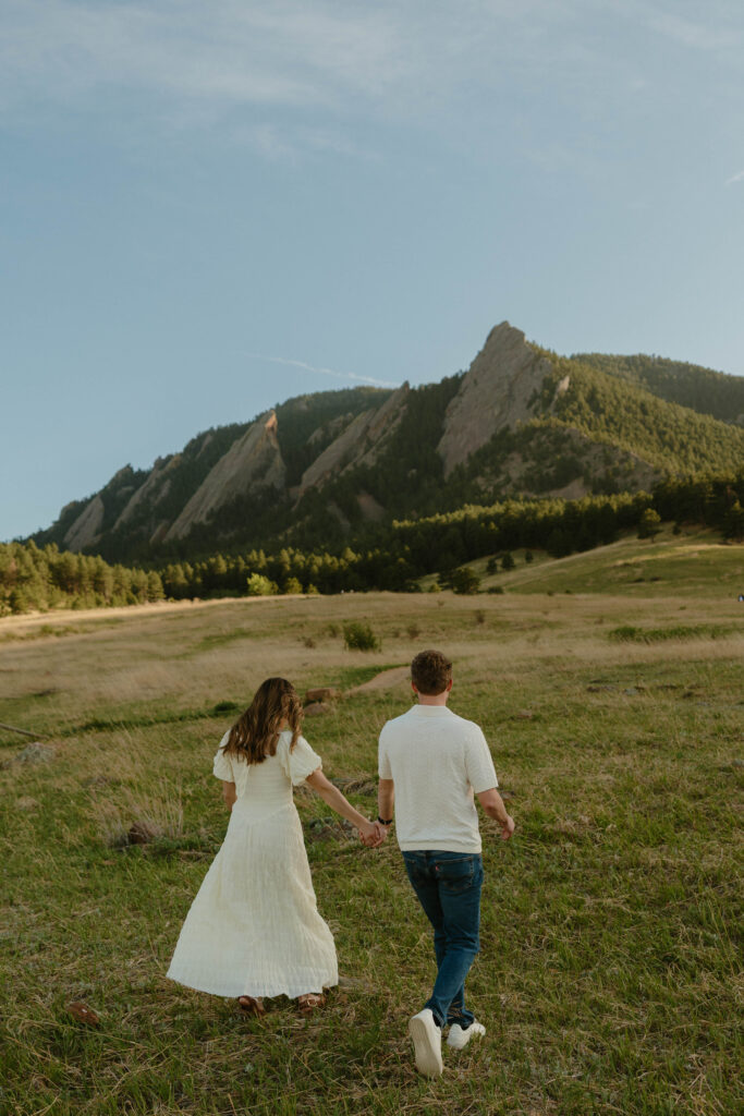 Couple holding hands walking during Colorado engagement session