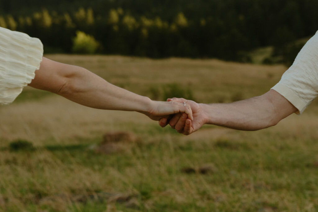 couple grabbing hands during colorado engagement session