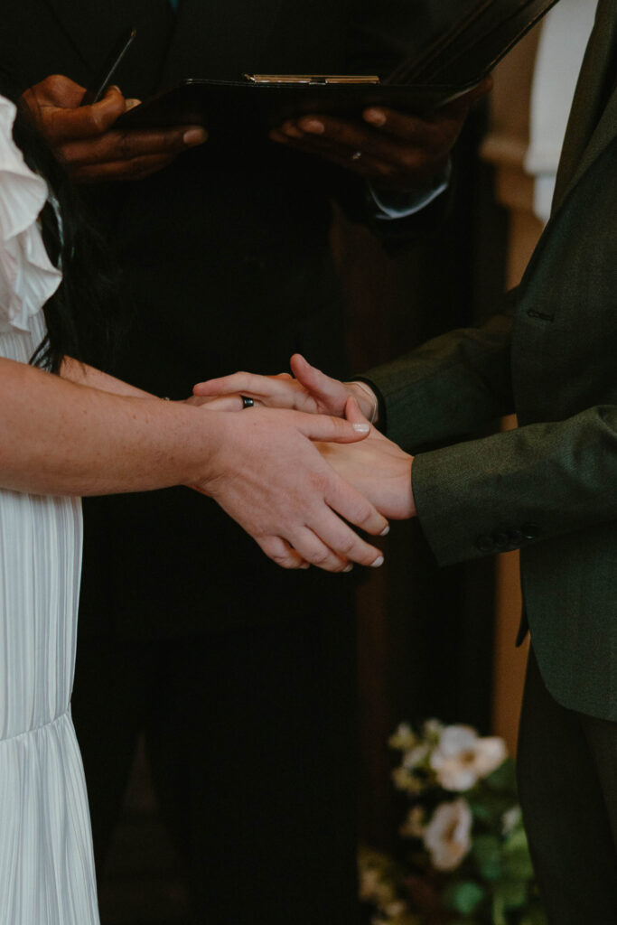 detail of hands clasped together during wedding ceremony 