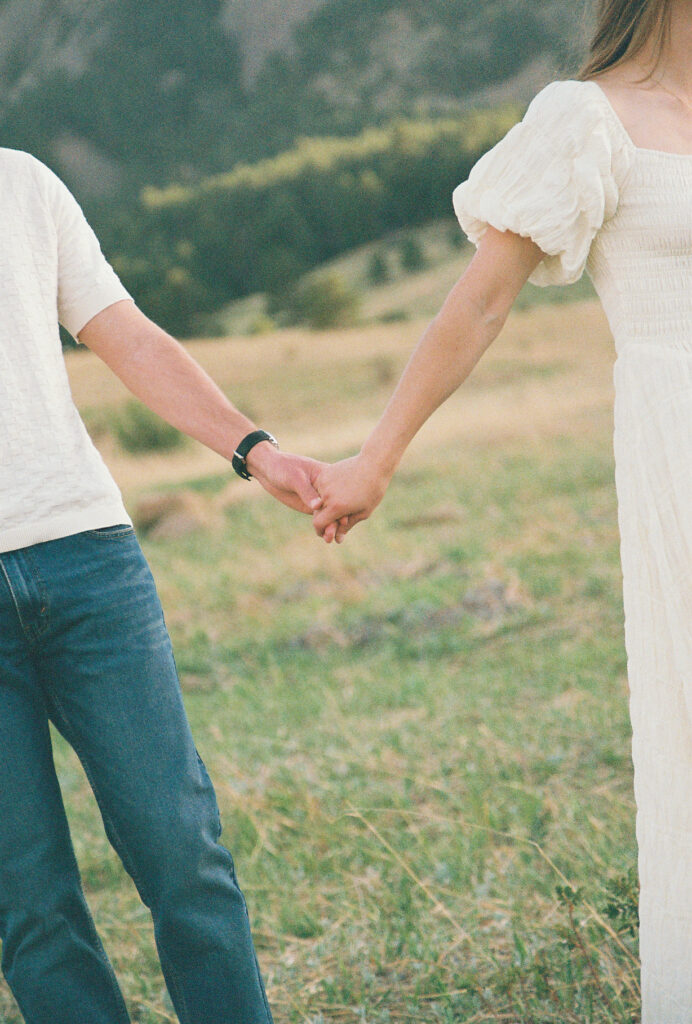 Couple holding hands walking during Colorado engagement session