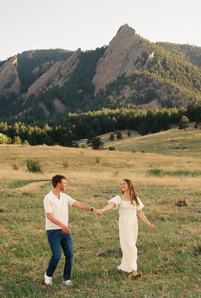 Couple holding hands walking during Colorado engagement session