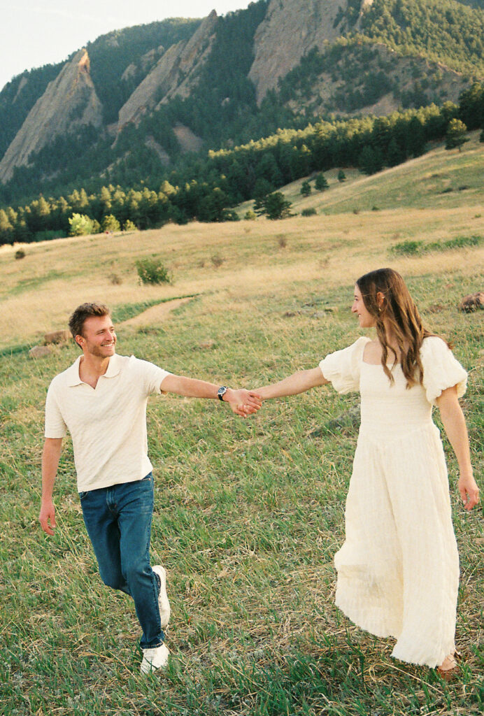 Couple holding hands walking during Colorado engagement session