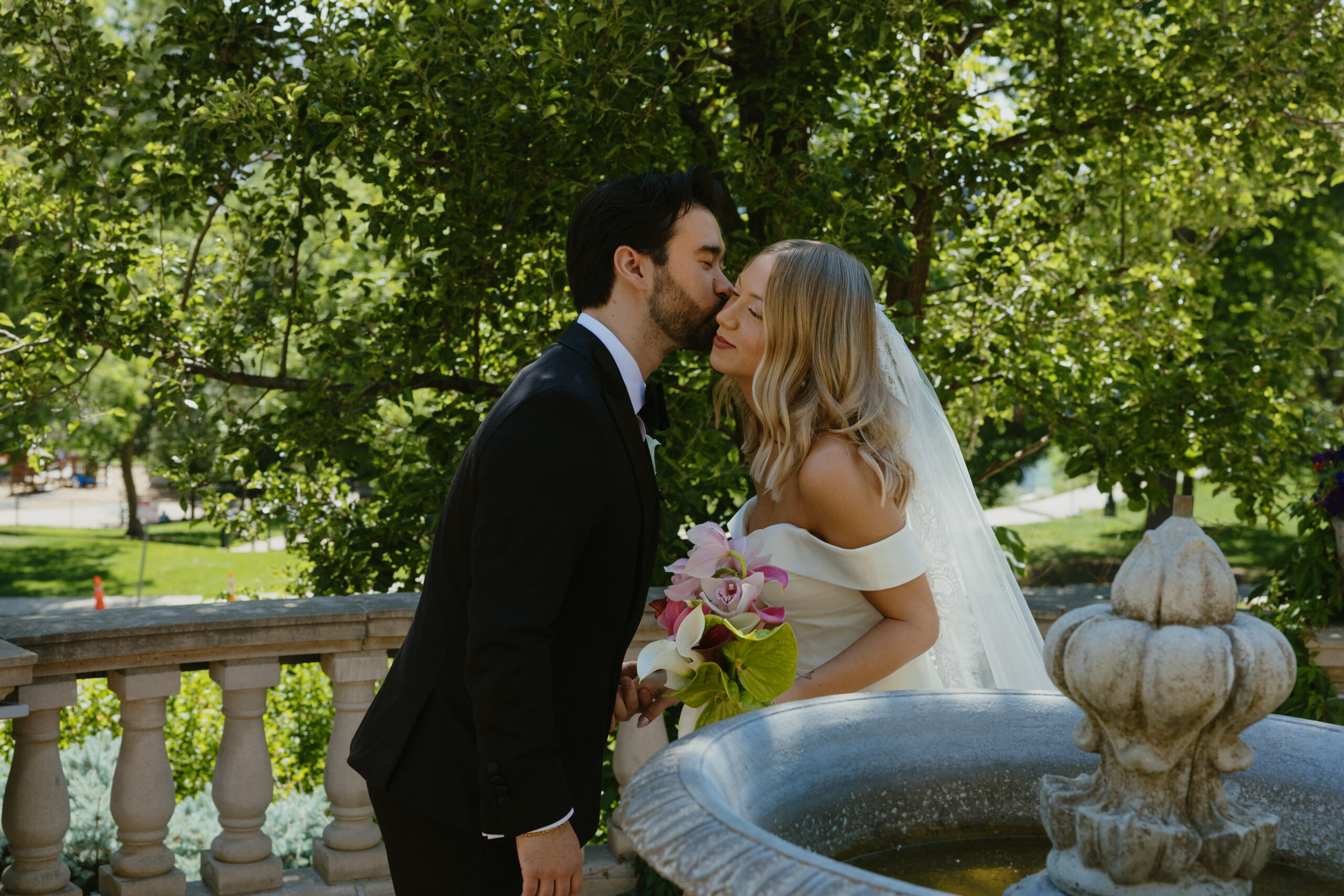 groom kissing brides cheek at Grant Humphreys Mansion